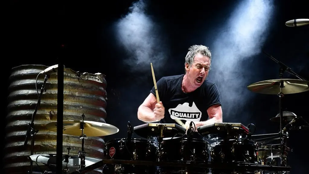Rob Hirst playing drums—concert photo by Tony Mott